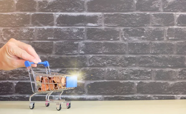 shopping cart with boxes on brick wall background.