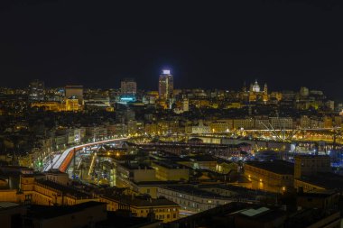 Panoramic view of Genoa at night with the causeway and the buidings of the historic center, Italy