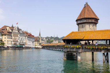LUCERNE, SWitzERLAND, 21 Haziran 2022 - Reuss nehri üzerindeki Kapellbrucke Köprüsü ve İsviçre 'nin başkenti Lucerne' deki binaların manzarası