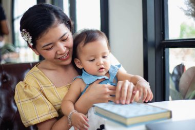 Anne ve kızı rahatlayın ve bir kitap okuyun.