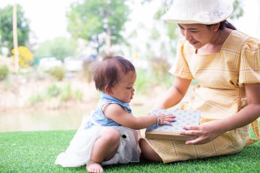 Anne ve kızı rahatlayın ve bir kitap okuyun.