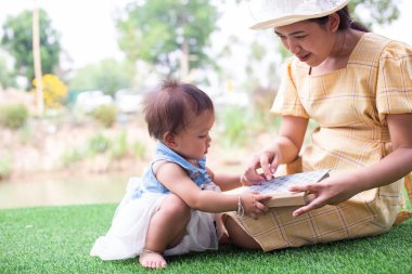 Anne ve kızı rahatlayın ve bir kitap okuyun.