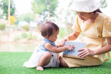 Anne ve kızı rahatlayın ve bir kitap okuyun.
