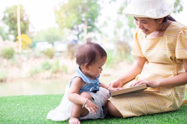 Anne ve kızı rahatlayın ve bir kitap okuyun.