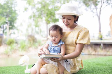 Anne ve kızı rahatlayın ve bir kitap okuyun.