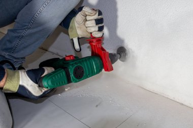 Daha sonra elektrik kablolarının ve duvar prizinin yerleştirileceği bir bağlantı kutusunun hazırlanması için beton duvarda bir delik açmak, Hollanda
