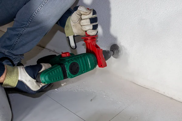 Daha sonra elektrik kablolarının ve duvar prizinin yerleştirileceği bir bağlantı kutusunun hazırlanması için beton duvarda bir delik açmak, Hollanda
