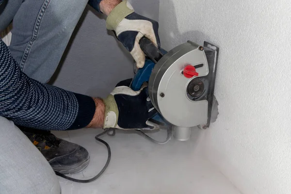 PVC boruları döşemek ve ev ve işletmelerde elektrik tesisatı kurmak için beton duvarlarda geniş oyuklar açmak için öğütücü bir makine.