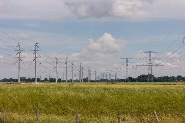 Expansion of the high-voltage grid with many high-voltage pylons to meet the growing demand for electricity, photo taken in the province of Groningen, the Netherlands