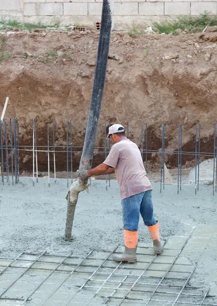 Constructor trabajador con tubo bomba cemento — Foto de Stock