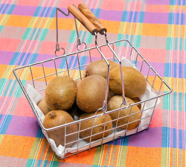 Basket of kiwi on tablecloth — Stock Photo, Image