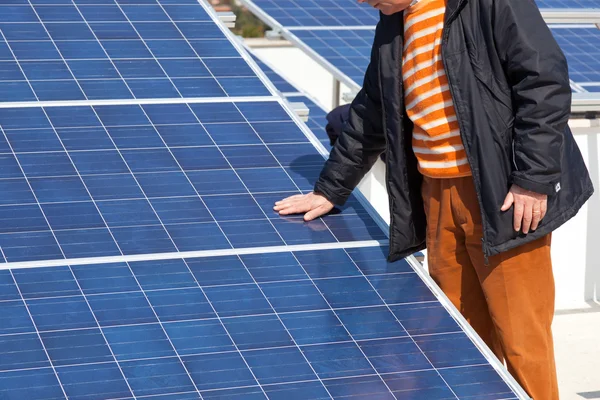 Hand op zonnepaneel — Stockfoto