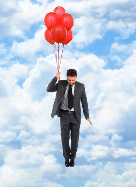 Empresario volando con globos rojos —  Fotos de Stock