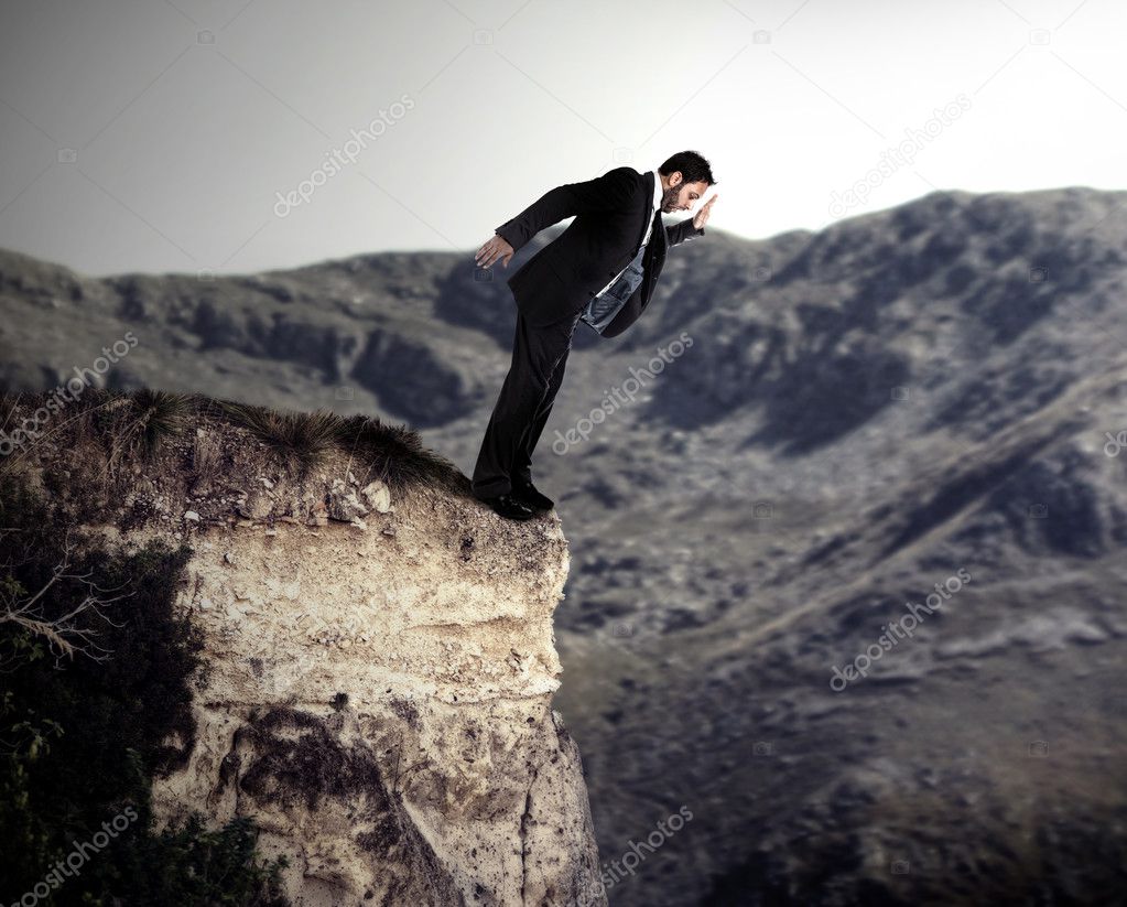 Young businessman falls from the cliff