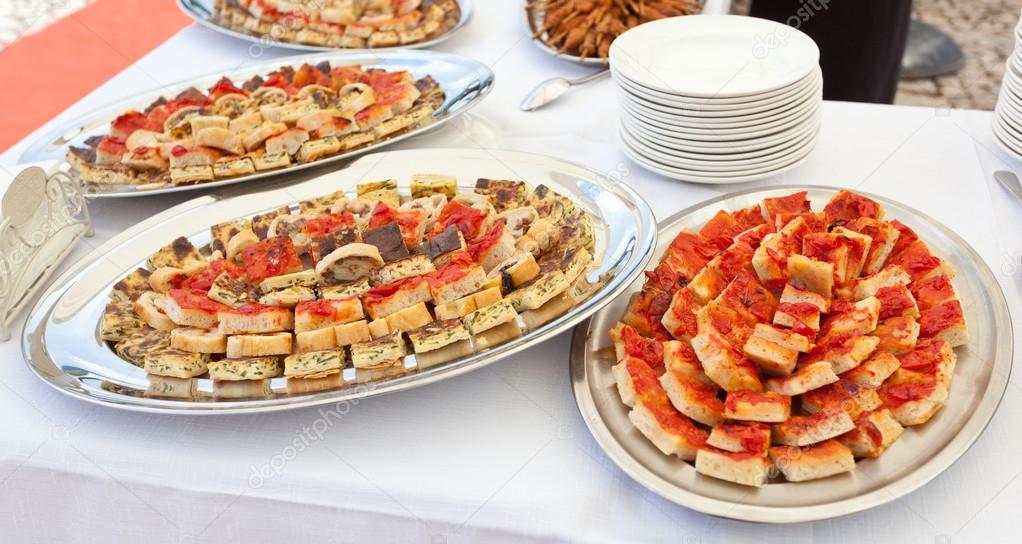 Trays with pieces of tomato pizza, omelets and rustic