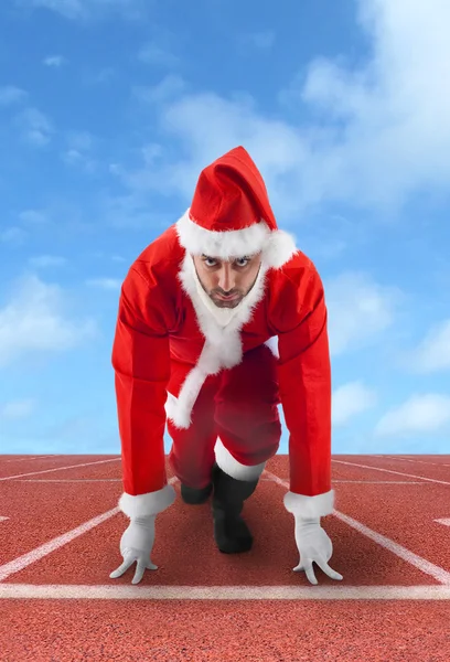 Santa Claus in the starting position on a running track — Stock Photo, Image