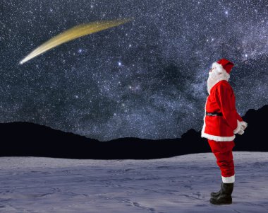 Noel Baba gökyüzünde kayan bir yıldız ile görünüyor.
