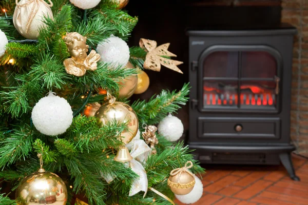 Christmas decorations on a tree with the bottom of a fireplace — Stock Photo, Image