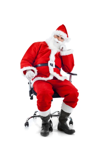 Young Santa Claus sitting on an office chair. — Stock Photo, Image