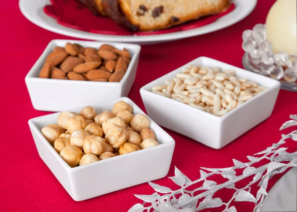 Pine nuts, almonds and hazelnuts in bowls on the Christmas table — Stock Photo, Image
