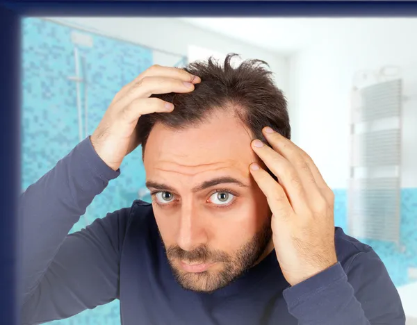 Homme contrôle la perte de cheveux — Photo