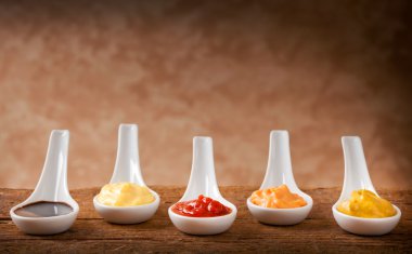 Sauces mixed in the ceramic spoons clipart