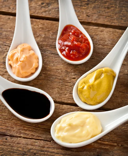 Sauces mélangées dans les cuillères en céramique — Photo