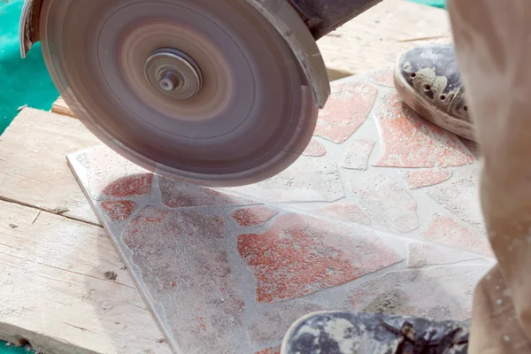 Мужчина режет плитку на полу — стоковое фото