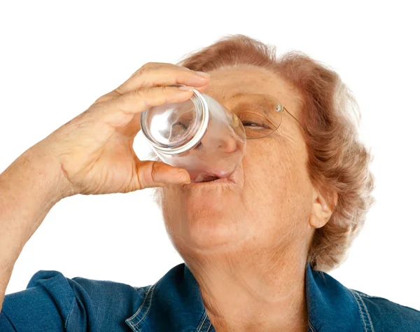 Пожилая женщина со стеклом для воды — стоковое фото