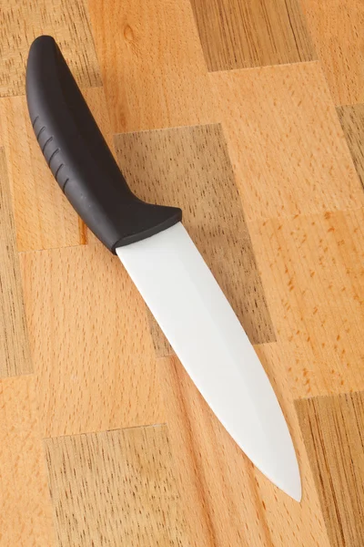 Ceramic knife on wooden cutting board — Stock Photo, Image