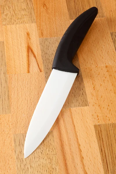 Ceramic knife on wooden cutting board — Stock Photo, Image