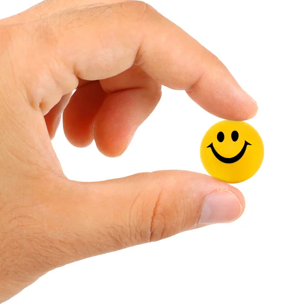 Мяч с улыбкой между пальцами — стоковое фото