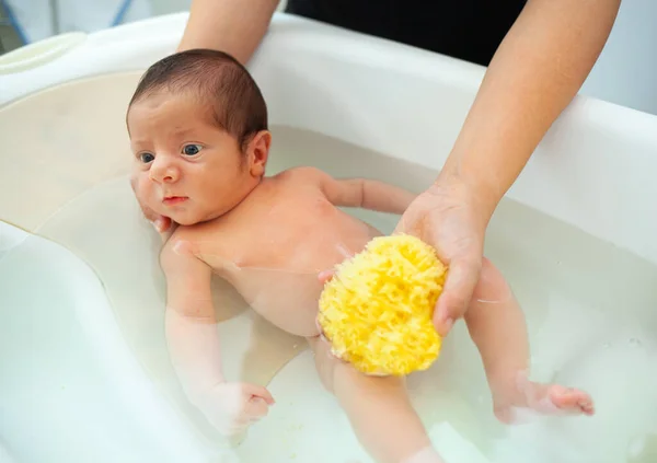 新生児の男の子の最初の風呂 お母さんは自然なスポンジで赤ちゃんを洗います — ストック写真