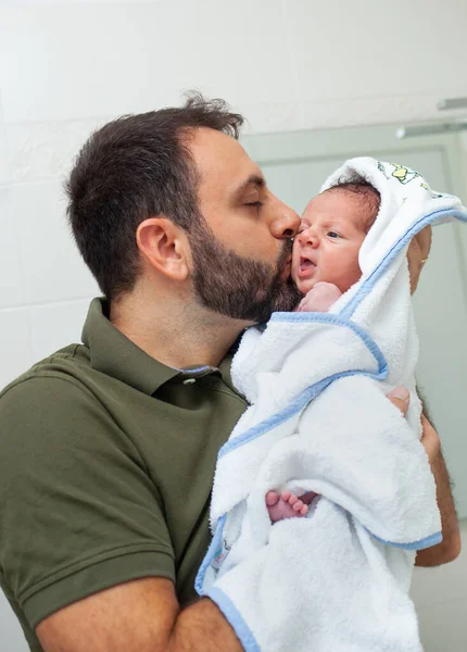 新生児の男の子の最初の風呂 赤ん坊は父親の腕のバスローブにいる — ストック写真