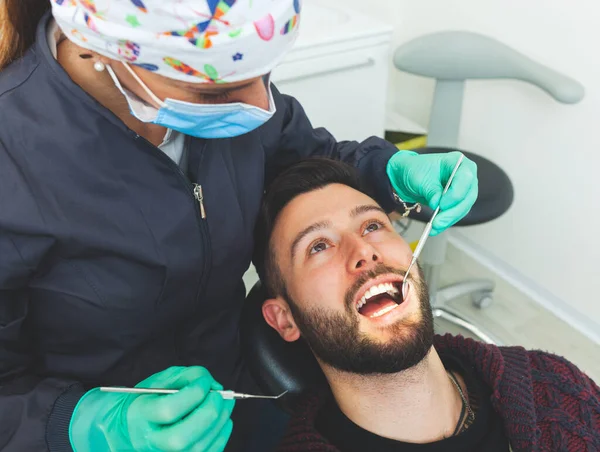 Dentista Donna Esamina Paziente Uno Studio Odontoiatrico Utilizzando Strumenti Professionali — Foto Stock