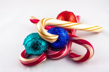 Four candy cans and three chocolat balls on a white background clipart