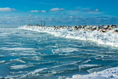 İskelede deniz feneri olan buzlu bir manzara.