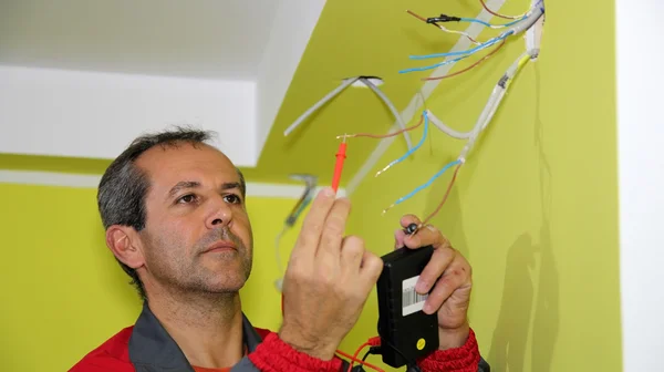 Electricista trabajando con instrumentos de medición y cables — Foto de Stock