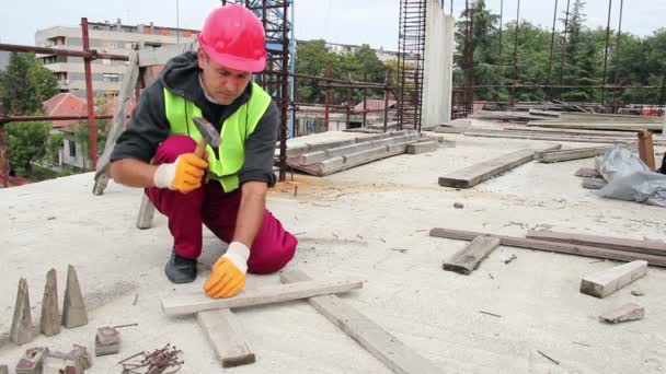 Trabajador manual usando martillo en el sitio de construcción — Vídeos de Stock