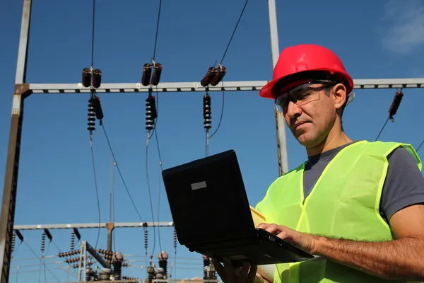 Engenheiro usando laptop em uma subestação elétrica . — Fotografia de Stock