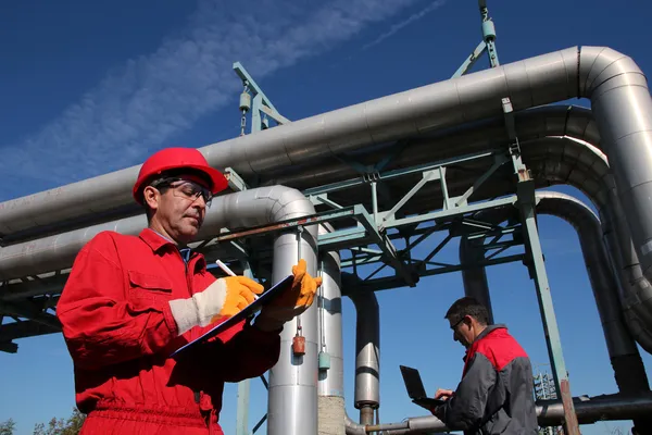 Dos ingenieros industriales trabajando en una fábrica . — Foto de Stock