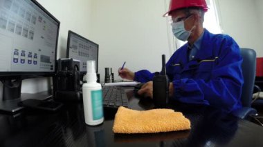 Koronavirüs salgını sırasında yüz maskeli bir mühendis fabrika kontrol odasında çalışıyor. Coronavirus koruma konsepti HD1080p