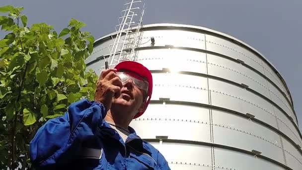 Pracownik Niebieskich Kombinezonach Okularach Noszący Czerwony Twardy Kapelusz Korzystający Krótkofalówki — Wideo stockowe