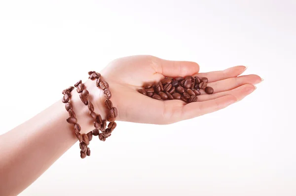 Coffee beans on a female hand with a coffee bracelet — Stock Photo, Image
