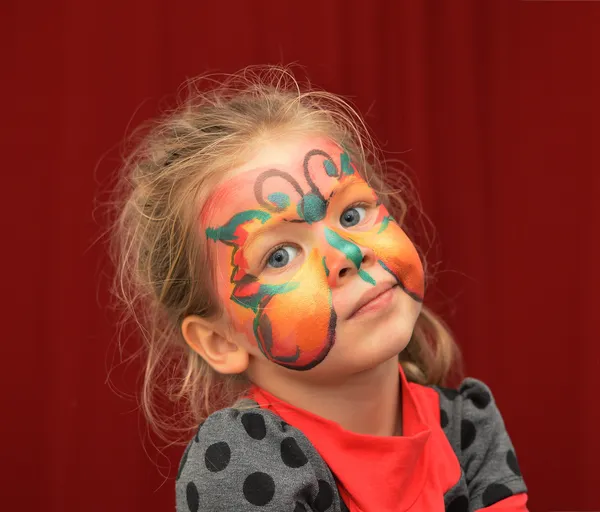 Malá holčička namalovaný obličej jako motýl — Stock fotografie