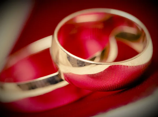 Anillos de oro de la boda sobre fondo rojo —  Fotos de Stock