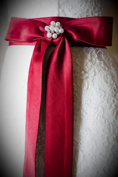 Red ribbon on wedding dress — Stock Photo, Image