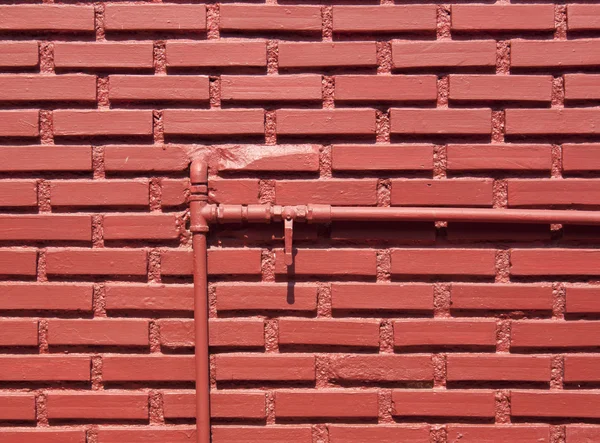 Стена из красного кирпича с водопроводами — стоковое фото