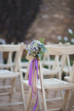 Düğün davetlilerinin çiçekli sandalyeleri.