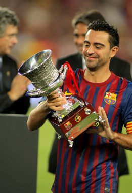 Xavi Hernandez of FC Barcelona holds up Supercup clipart